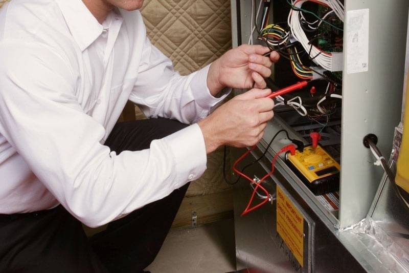 furnace services being done by a technician 